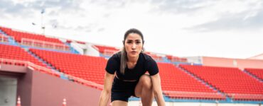 Asian young sportswoman sprint on a running track outdoors on stadium.