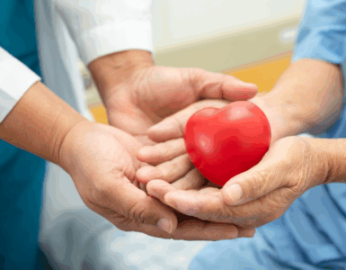 Healthcare professional and patient holding a red heart symbolizing heart health and compassionate care.