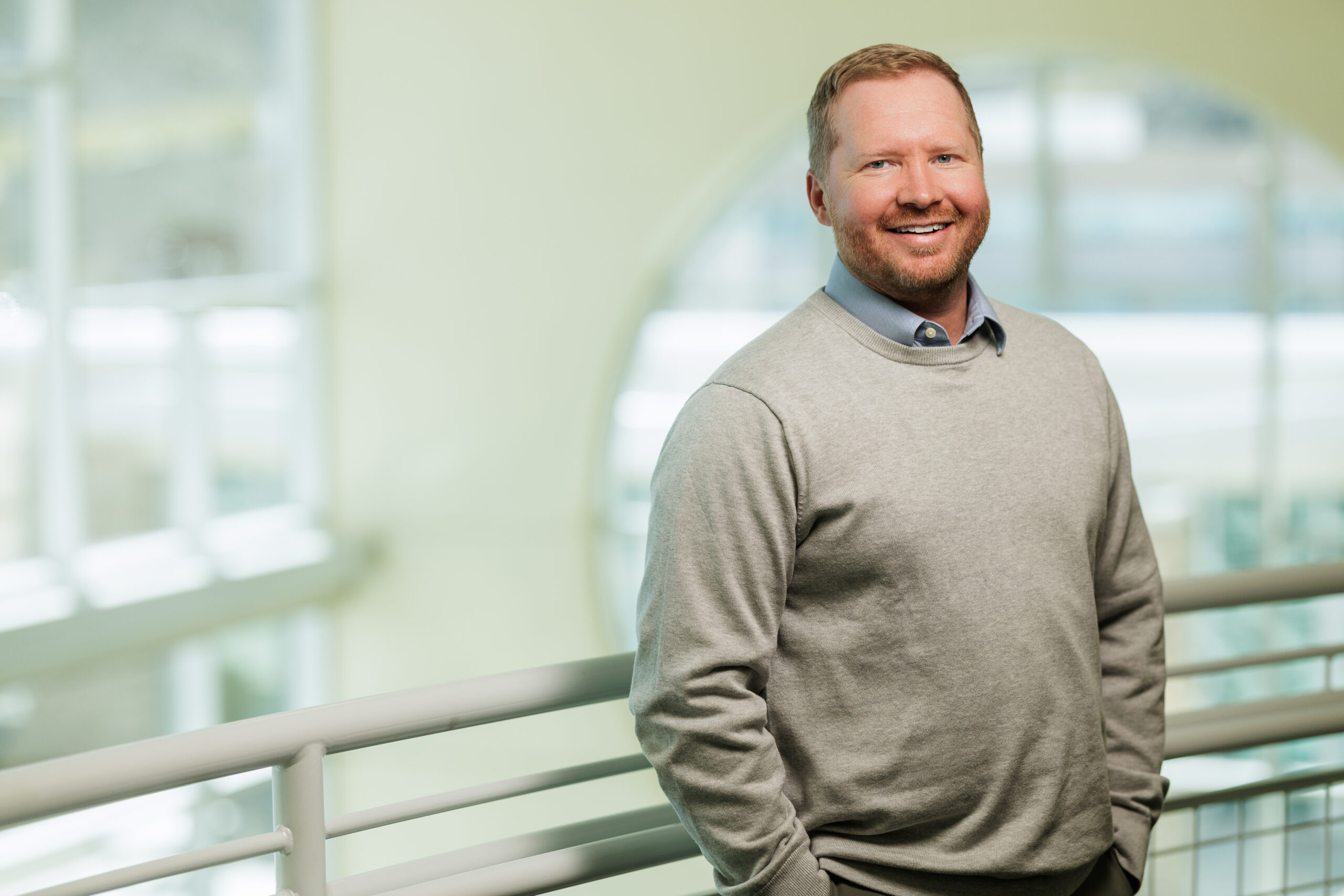 Dylan Linnell, PA-C, standing indoors at Carson Tahoe Health, smiling in a light sweater in a hospital setting.