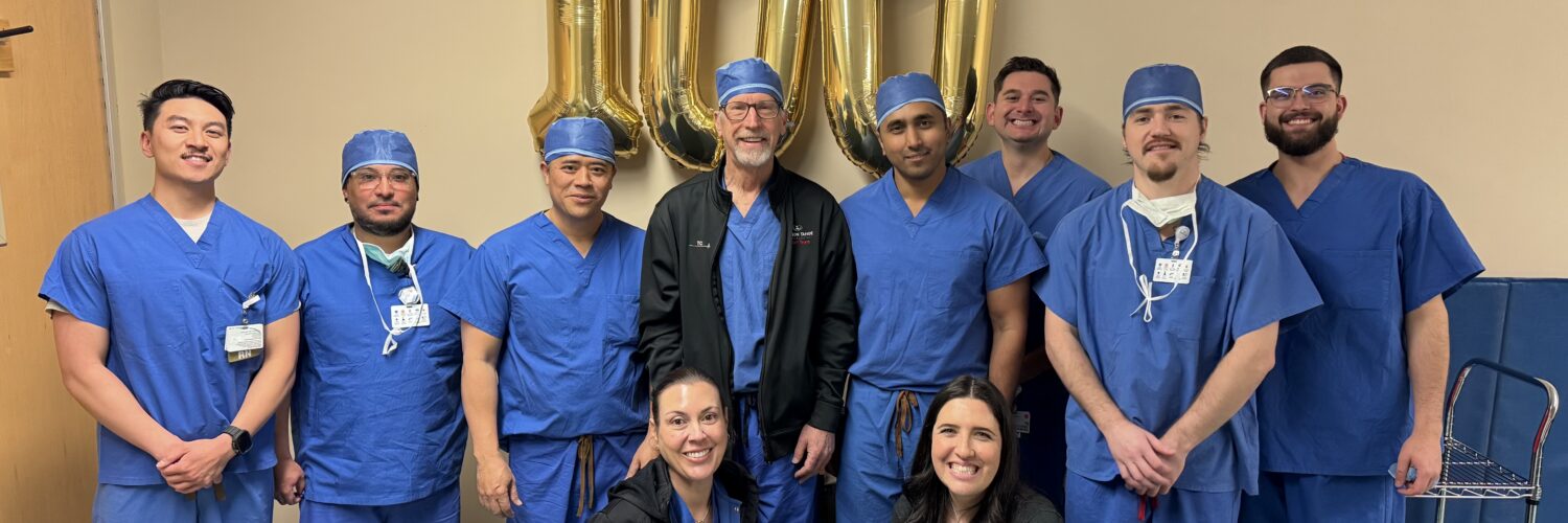 Carson Tahoe Health cardiovascular team celebrating 100th TAVR procedure milestone with staff standing in scrubs in front of gold 100 balloons