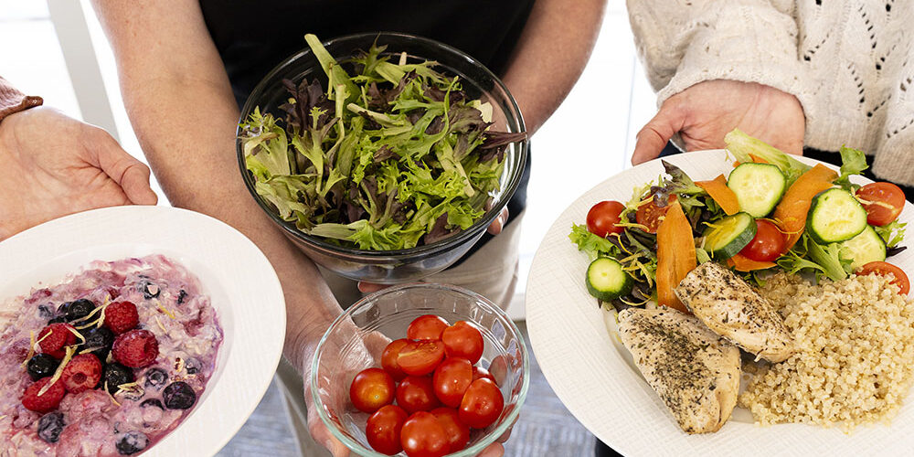 Healthy meal with salad, quinoa, grilled chicken, fresh vegetables, and berry yogurt for balanced nutrition