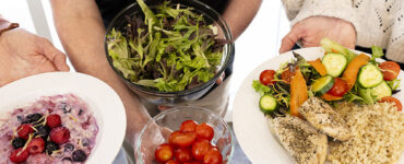 Healthy meal with salad, quinoa, grilled chicken, fresh vegetables, and berry yogurt for balanced nutrition