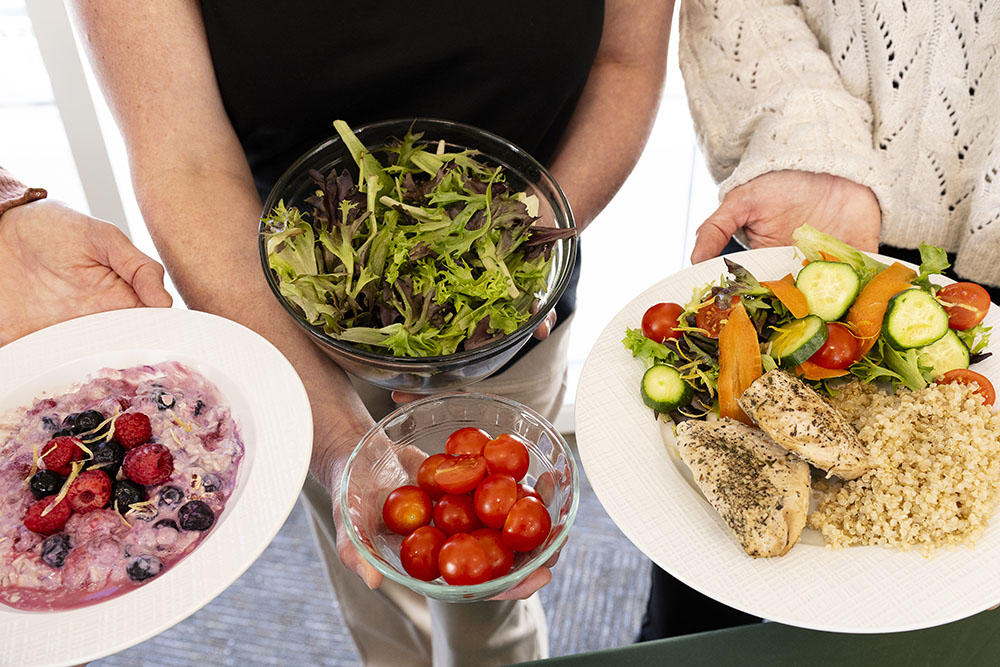 Healthy meal with salad, quinoa, grilled chicken, fresh vegetables, and berry yogurt for balanced nutrition
