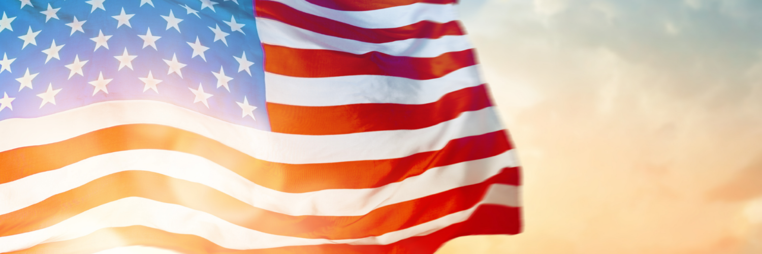 American flag waving in the wind against a sunset sky, symbolizing Independence Day and patriotism