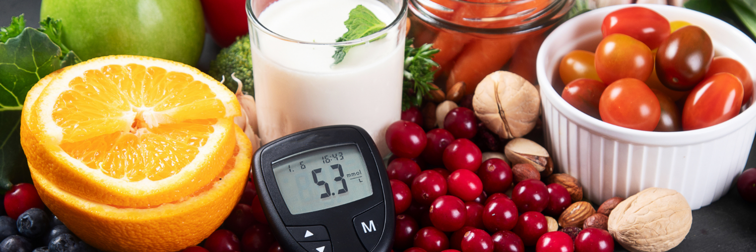 Healthy foods including fruits, vegetables, nuts, and milk with a glucose meter showing blood sugar levels, representing diabetes prevention and healthy lifestyle