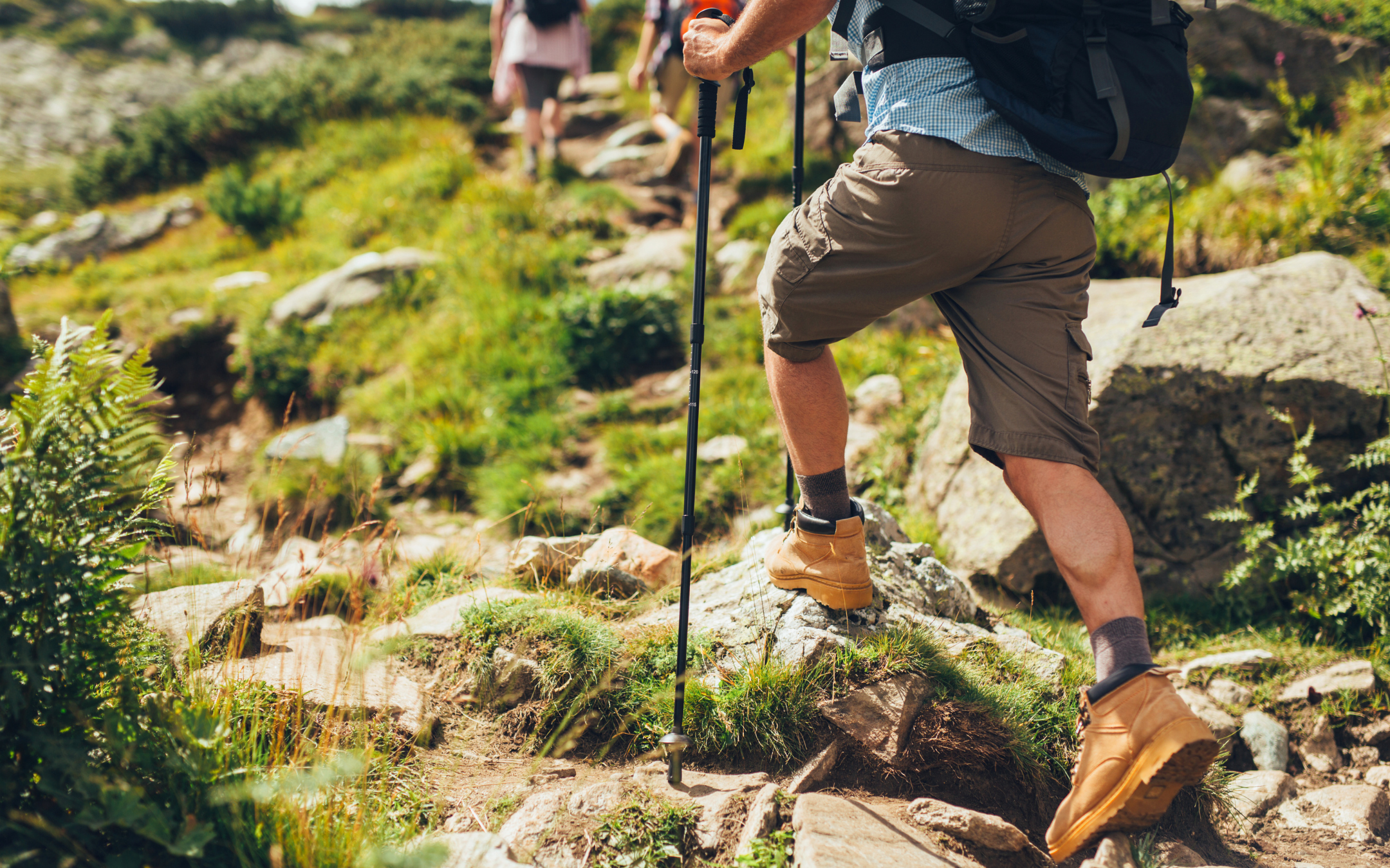 Man hiking outdoors on a scenic trail as part of an active and healthy lifestyle.