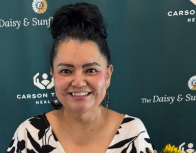 Alba Alegria holding her Sunflower Award and a bouquet of sunflowers at Carson Tahoe Health