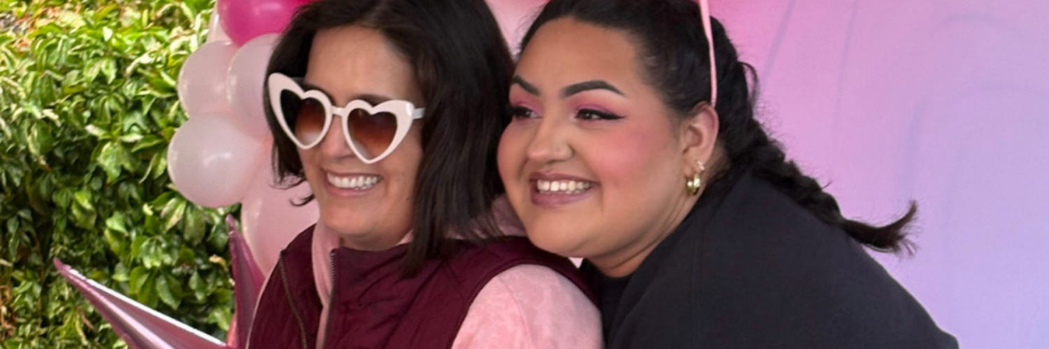 Two women smile in front of a pink balloon arch at Carson Tahoe Health’s Think Pink+ event in Carson City.