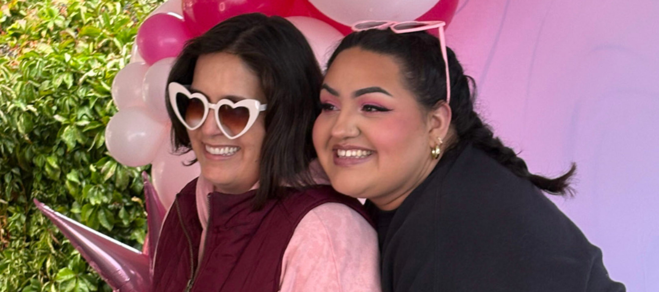 Two women smile in front of a pink balloon arch at Carson Tahoe Health’s Think Pink+ event in Carson City.