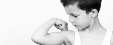 Picture of a small boy flexing his muscle