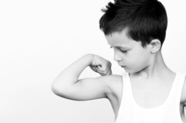 Picture of a small boy flexing his muscle